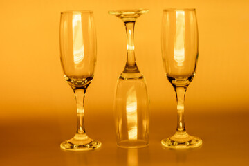 Empty champagne glasses on orange background, neon champagne glasses, spotkanie. Podświetlane, przezroczyste szkło - obrazy, fototapety, plakaty