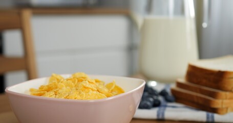 Selected beautiful breakfast cereals are cinematically poured into bowl. Cinematic slow-mo advertisement breakfast without people ideal morning for happy family Breakfast aesthetics delicious food.