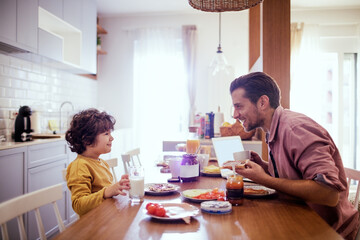 Father and son enjoying breakfast at home