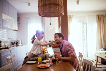 Father and daughter enjoying breakfast at home