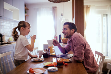 Father and daughter enjoying breakfast at home