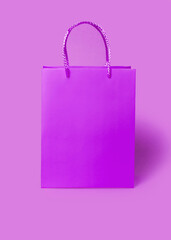 Pink purple paper shopping bag on pink purple background. Shopping sale delivery concept. Packaging gift.