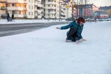 A young girl falls on a winter walk.
