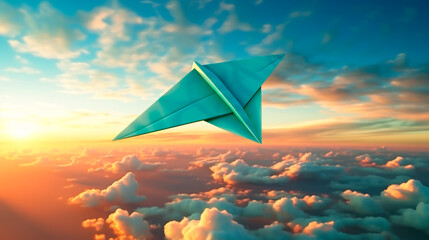 A green colored paper airplane flies in the blue sky with clouds at sunset, seen from above,