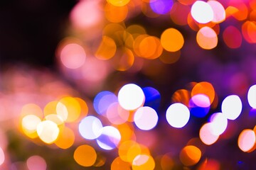 A mesmerizing image captures the enchanting glow of blurred lights on a Christmas tree, creating a...