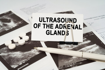 On the ultrasound pictures there is a pen and a business card with the inscription - Ultrasound of...