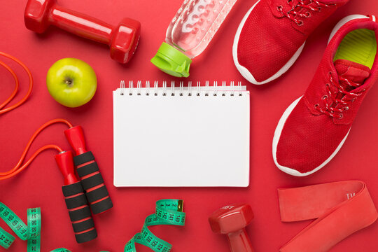 Sport equipment with tape measure on color background, top, view. Weight loss concept