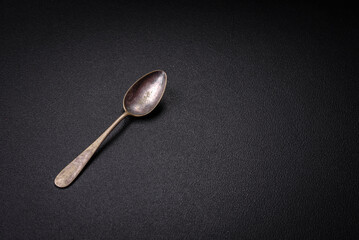 Empty metal spoon on dark textured concrete background