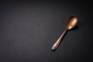 Empty metal spoon on dark textured concrete background