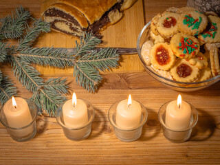Christmas. Advent. Antique-style still life with candles, cake and poinsettia christmas star plant.