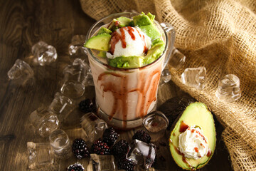 Avocado and mulberry lava drink served in disposable glass isolated on table side view of healthy...