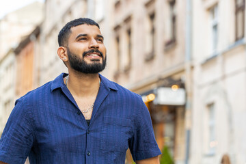 Bearded indian man tourist walking in urban city street background in summer daytime. Adult guy...