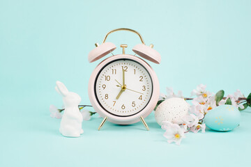 Cute easter bunny or rabbit with an alarm clock, eggs and cherry blossoms, spring holiday, greeting...