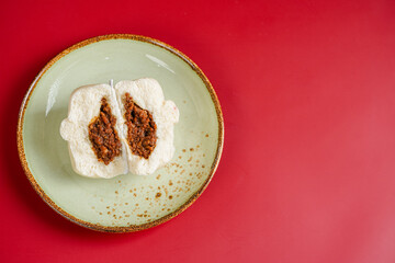 Baozi or Bakpao is a type of yeast-leavened filled bun in various Chinese cuisines. Baozi in Red Background