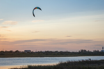 Sportsman kitesurfing during sunset
