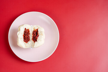 Baozi or Bakpao is a type of yeast-leavened filled bun in various Chinese cuisines. Baozi in Red Background