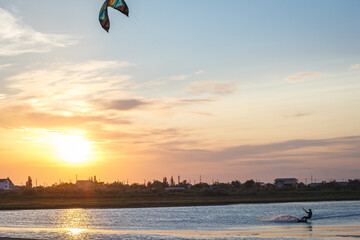 Sportsman kitesurfing during sunset