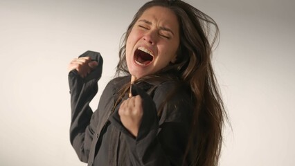 Portrait of attractive female model in negative mood. Studio shot of brunette woman in hysterical...