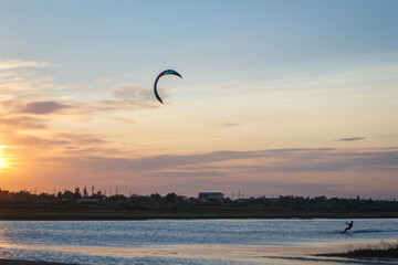 Sportsman kitesurfing during sunset