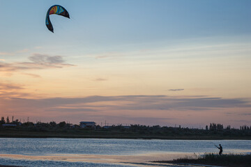 Sportsman kitesurfing during sunset