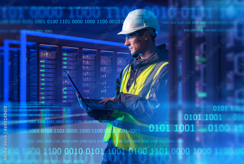 Poster man system administrator. engineer with laptop stands in server room. system administrator among bin