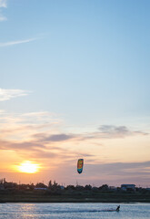 Sportsman kitesurfing during sunset