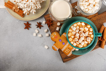 Hot drink with marshmallows and candy cane in  cup on a texture table.Cozy seasonal holidays.Hot cocoa with gingerbread Christmas cookies.Hot chocolate with marshmallow and spices.Copy space.