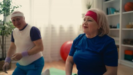 Happy senior man and woman getting fit together, doing stretching exercises