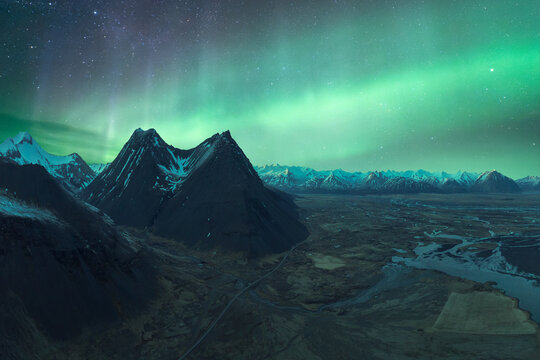 Majestic mountain peaks under the green glow of the Northern Lights in Vatnaj&ouml;kull National Park, Iceland