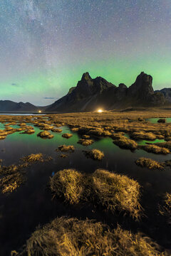 Northern lights over mountainous landscape at night in Eystrahorn, Iceland