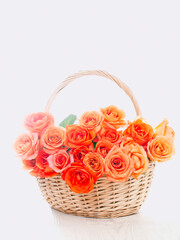 Fototapeta na wymiar Wicker basket with orange roses