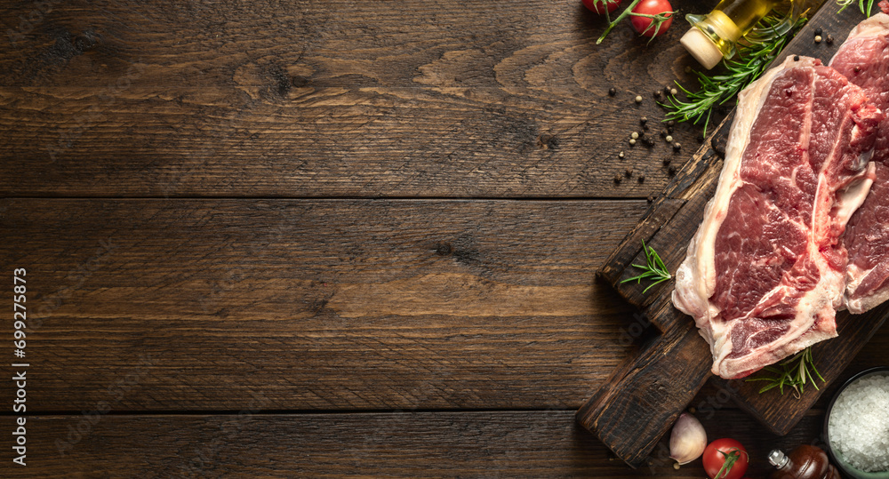 Poster two raw beef steak on wooden board on wood table with copy space top view