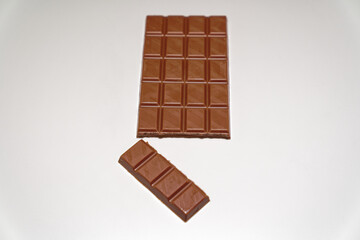 Close-up of  broken brown Swiss milk Chocolate bar against white background. Photo taken December 27th, 2023, Zurich, Switzerland.