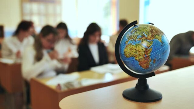A globe of the world in a school classroom during a lesson.