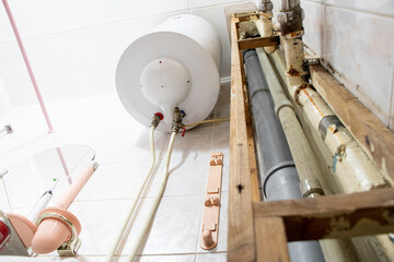 Water heater and pipes in a residential apartment after replacing the pipe with a new one, bathroom