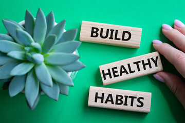 Healthy habits symbol. Concept word Build Healthy habits on wooden blocks. Doctor hand. Beautiful...