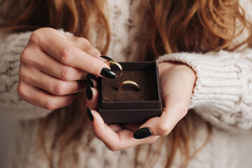 Wedding ring background. Girl holding rings. Woman hands with giftbox wedding ring. Shallow depth...