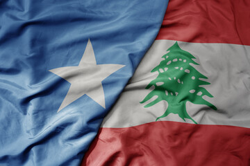 big waving national colorful flag of lebanon and national flag of somalia .