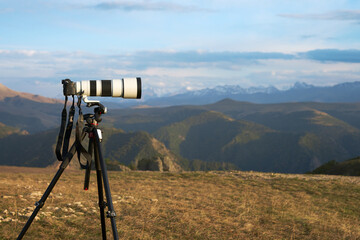 Photography of a distant object at long shutter speed. A camera with a long lens on a tripod...