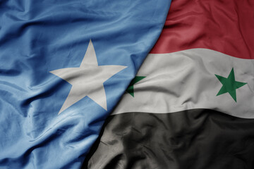 big waving national colorful flag of syria and national flag of somalia .
