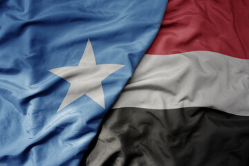 big waving national colorful flag of yemen and national flag of somalia .