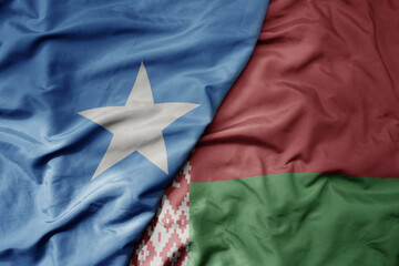 big waving national colorful flag of belarus and national flag of somalia .