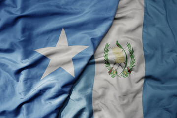 big waving national colorful flag of guatemala and national flag of somalia .