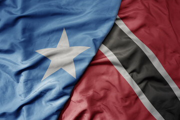 big waving national colorful flag of trinidad and tobago and national flag of somalia .