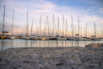 Tuinposter Yachts in the port, sailboats modern water transport. Beautiful moored sail yachts in the sea © Natalya Nepran