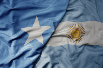 big waving national colorful flag of argentina and national flag of somalia .