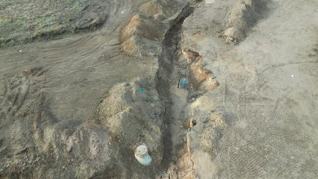 sewer excavations and piles of earth at the construction site documentation with drone photos operator. rows of trenches are mapped by a fast messenger on a bicycle. sewer pipe, upper view