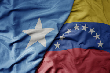 big waving national colorful flag of venezuela and national flag of somalia .