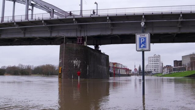 Flooding of the river Rhine, Arnhem, the Netherlands. In the background the John Frost bridge. The road is not accessible because of the high water level.