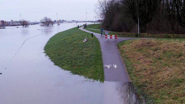 Flooding of the river Rhine, Arnhem, the Netherlands, bike path is not accessible because of the high water level. The water reaches the dike.